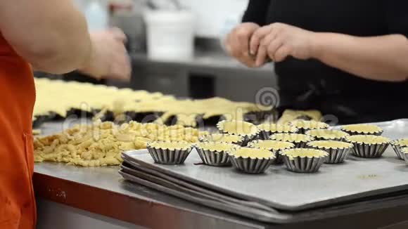 糕点厨师在糕点店的厨房里做馅饼把面团放进烤盘里视频的预览图