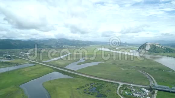 空中无人机在绿色草地与河流山脉背景下观赏美丽的自然风光视频的预览图