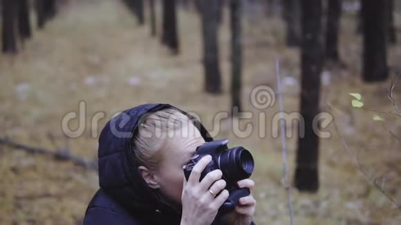 摄影师旅行者在秋天的森林里拍摄大自然的照片电影拍摄慢镜头拍摄视频的预览图