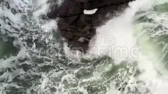 海浪拍打着黑色的岩石溅起了水花视频的预览图