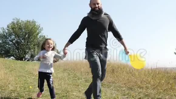 父亲带着两个女儿带着气球从山上跑下来视频的预览图