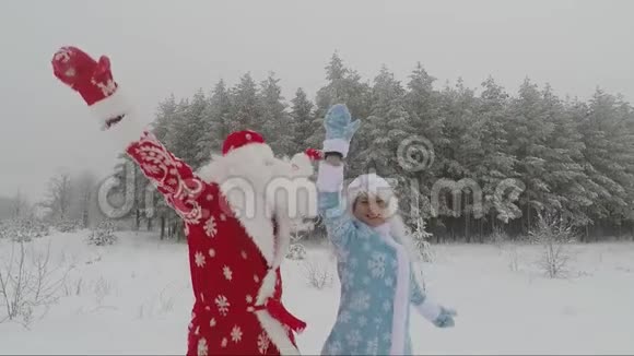 圣诞老人和孙女雪少女在白雪覆盖的森林里跳舞视频的预览图