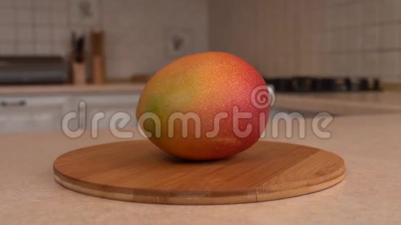 把新鲜的芒果果收起来旋转相机与白色厨房的背景多利射击视频的预览图