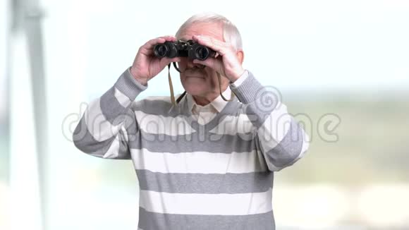 一个年长的男人透过一双望远镜视频的预览图
