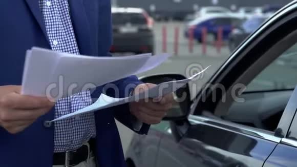 商人正站在汽车旁翻阅商业文件视频的预览图