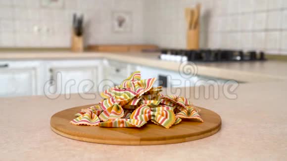 餐盘上有一堆法法勒阿科巴拉诺彩虹蝴蝶结意大利面旋转相机与白色厨房的背景多利射击视频的预览图