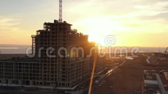 夕阳施工起重机在多层建筑中的鸟瞰施工视频的预览图