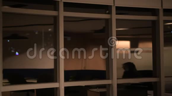 成熟的商人在办公室里夜以继日地透过窗户和思考视频的预览图