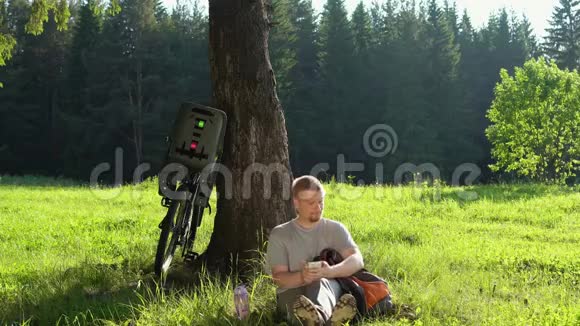 在阳光明媚的一天男子游客骑着自行车在夏天的森林里休息视频的预览图