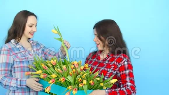 两个年轻可爱的带郁金香的花匠视频的预览图