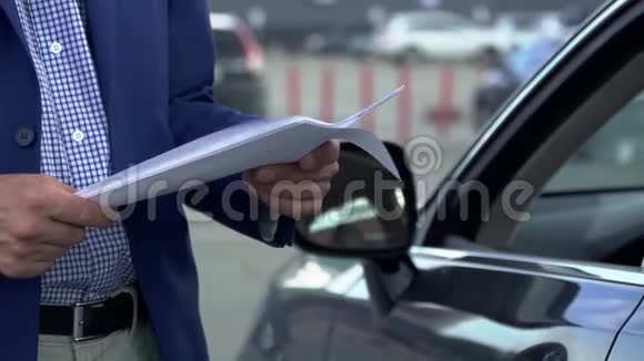 商人正站在汽车旁翻阅商业文件视频的预览图