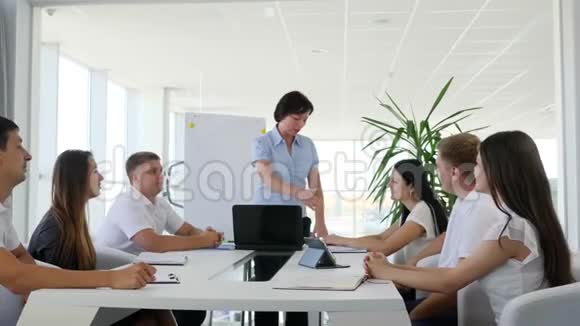 成功的商业伙伴在会议室的大桌子上握手和鼓掌视频的预览图