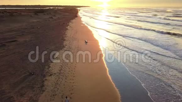 在日出时在海滩上慢跑的年轻有魅力的男人身上用无人机进行空中巡逻健身运动和健康运动视频的预览图