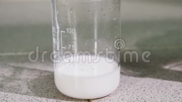 用白色粘稠液体倒入烧杯中的特写原油视频的预览图