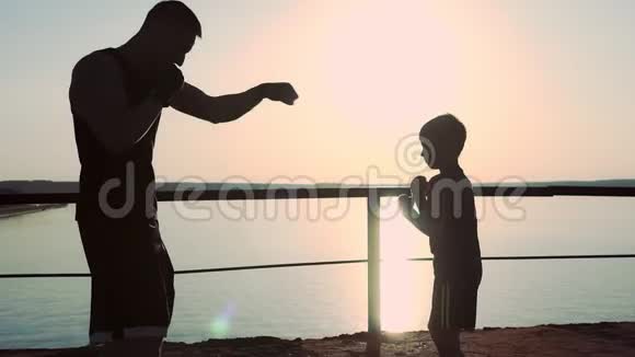 强壮的年轻高个子男拳击手教他的小儿子如何正确的拳击视频的预览图