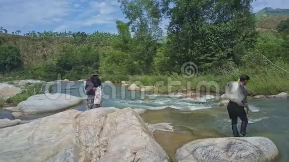 无人视野的人站在岩石上让人穿越河流视频的预览图