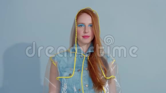穿着透明雨衣流行艺术鲜艳彩妆跳舞的姜发女人视频的预览图