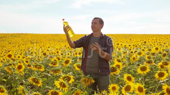 日落时分农夫手里拿着一瓶葵花油葵花籽油改善皮肤健康和生活方式视频的预览图