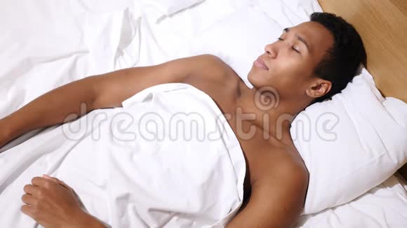夜晚躺在床上放松的非洲年轻人视频的预览图