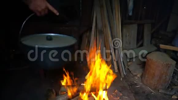 一个人把锅挂在火堆上煮白菜汤视频的预览图