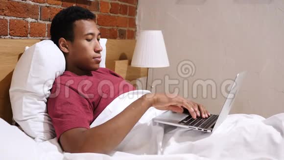 愤怒的沮丧的非洲男人在床上工作视频的预览图