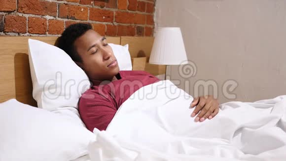 生病的非洲男人晚上躺在床上感觉不舒服视频的预览图