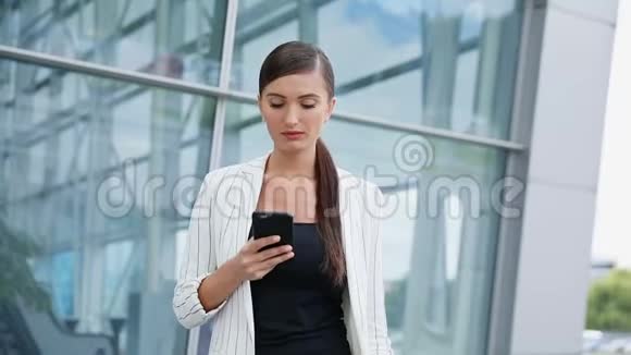 美丽的商务女性在办公室边走边打电话视频的预览图