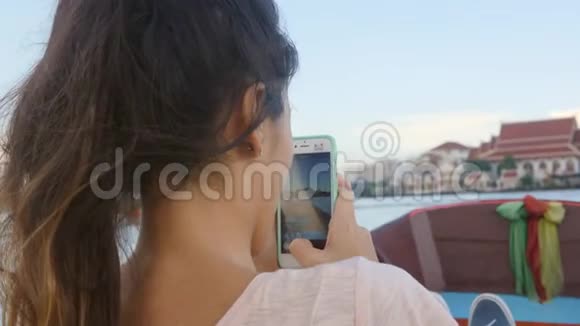 年轻快乐的旅游女孩在河上的船上航行在手机上拍摄视频泰国曼谷4K慢动作视频的预览图