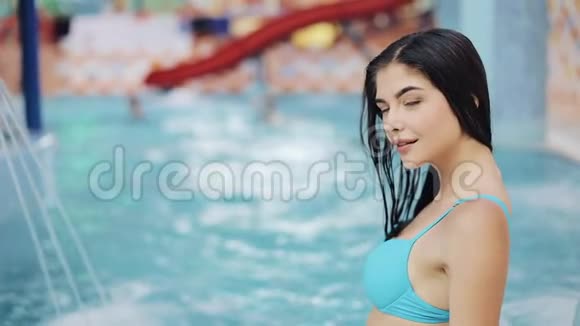 漂亮的女人坐在游泳池附近泳池边上那个被晒黑了的女孩视频的预览图