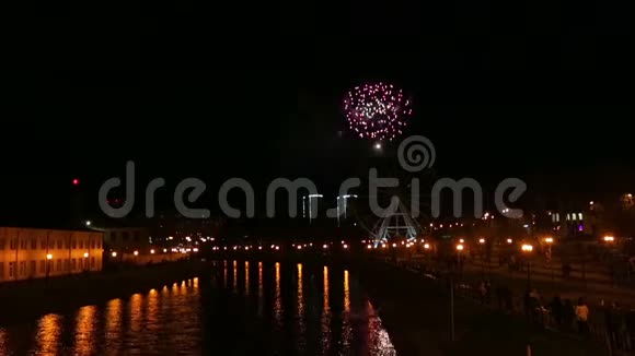 明亮的烟花在城市的夜空中映在河中视频的预览图