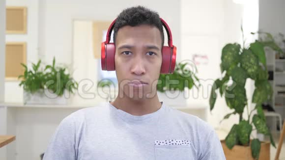 听音乐后非洲男子移除红色耳机视频的预览图