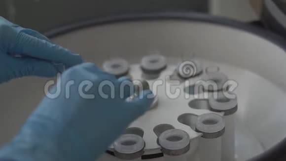 一位女科学家在实验室里将液体的唾液装入离心机视频的预览图