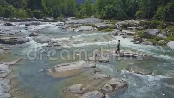 无人机显示一个人把钓鱼网扔到石头河里视频的预览图