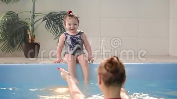 快乐微笑的幼儿在游泳池的水下跳跃和跳水水下射击缓动视频的预览图