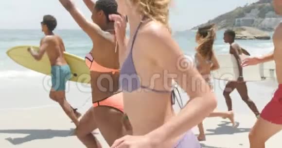 混合种族的朋友一起在海滩上跑步的侧面景色视频的预览图