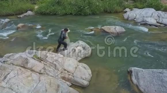 上景人攀上河岩石网入水视频的预览图