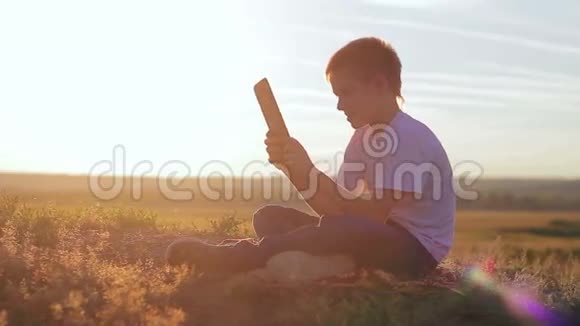 日落时坐着一个牌子的男孩视频的预览图