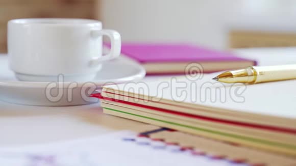 笔记本笔咖啡杯等配件放在办公桌上商人的工作场所视频的预览图