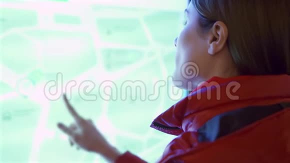 穿红色外套的年轻女人在户外使用触摸屏女性通过触摸屏幕做手势视频的预览图