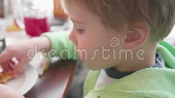 一个小孩子在快餐店吃披萨带有奶酪火腿西红柿和香草的比萨视频的预览图