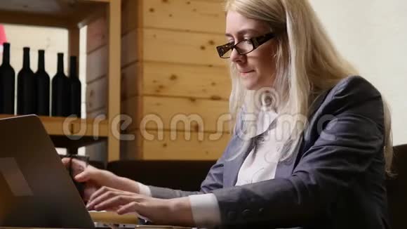 女商人手提电脑在咖啡馆喝果汁视频的预览图