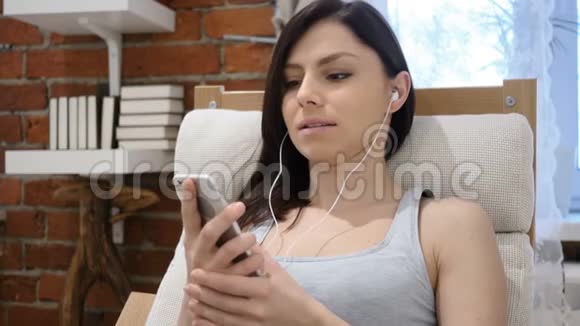 年轻女子智能电话听音乐视频的预览图