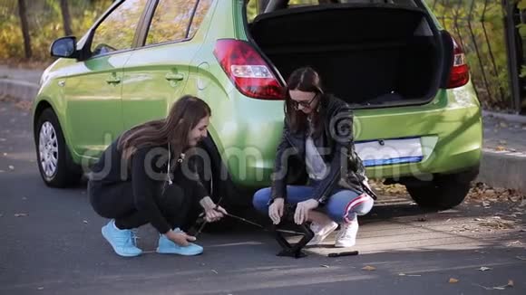 紧急情况两个女人在路边试图用杰克从你的车上换轮胎视频的预览图