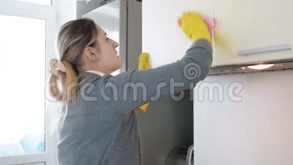 4k视频年轻家庭主妇抛光和清洁厨房橱柜视频的预览图