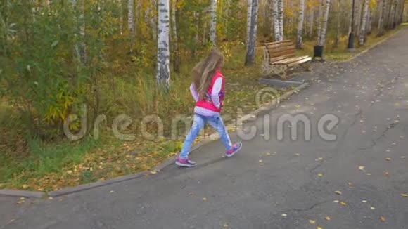 金发碧眼的女孩在秋天公园的小巷里奔跑头发嗖嗖的缓慢移动视频的预览图