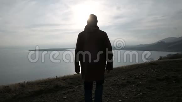 日落时分一个人独自在山上走向大海视频的预览图