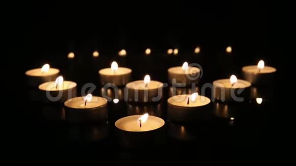 在黑镜背景上燃烧蜡烛燃烧蜡烛会同时褪色视频的预览图