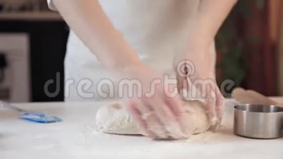 女人的手在工作在柜台上搅拌面团视频的预览图