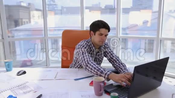 年轻的建筑师现代光明办公室的商人在电脑上工作有蓝图和计划视频的预览图