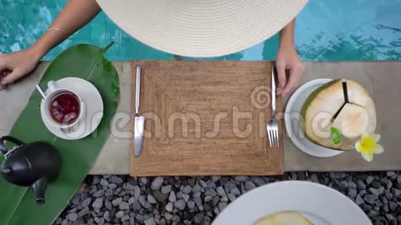 概念宣传完美早餐在游泳池旁女士在丛林的游泳池里吃早餐视频的预览图